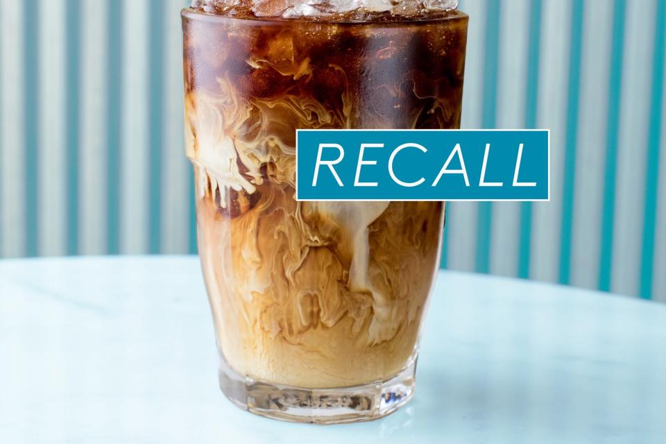 beautiful cold brew with cream swirling on white marble table