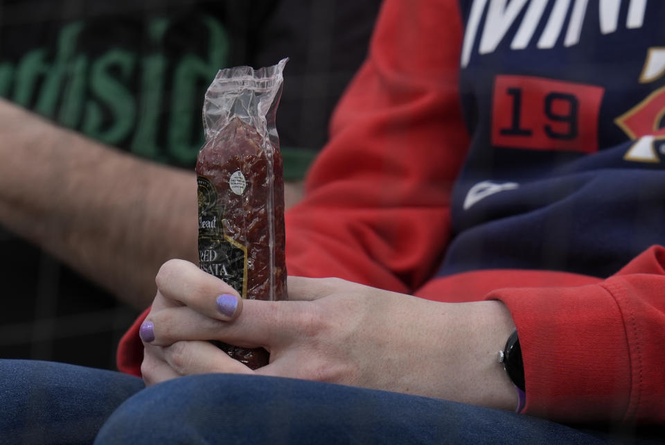 A Minnesota Twins fan holds a sausage before a baseball game against the Chicago White Sox, Monday, April 29, 2024, in Chicago. The Twins recently began passing around summer sausages in the dugout. (AP Photo/Erin Hooley)