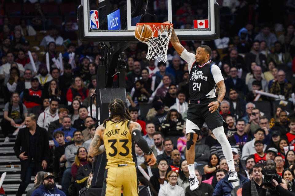 Los Angeles Clippers guard Norman Powell (24) dunks while Toronto Raptors guard Gary Trent Jr. (33) watches during the second half of an NBA basketball game in Toronto, Friday, Jan. 26, 2024. (Christopher Katsarov/The Canadian Press via AP)