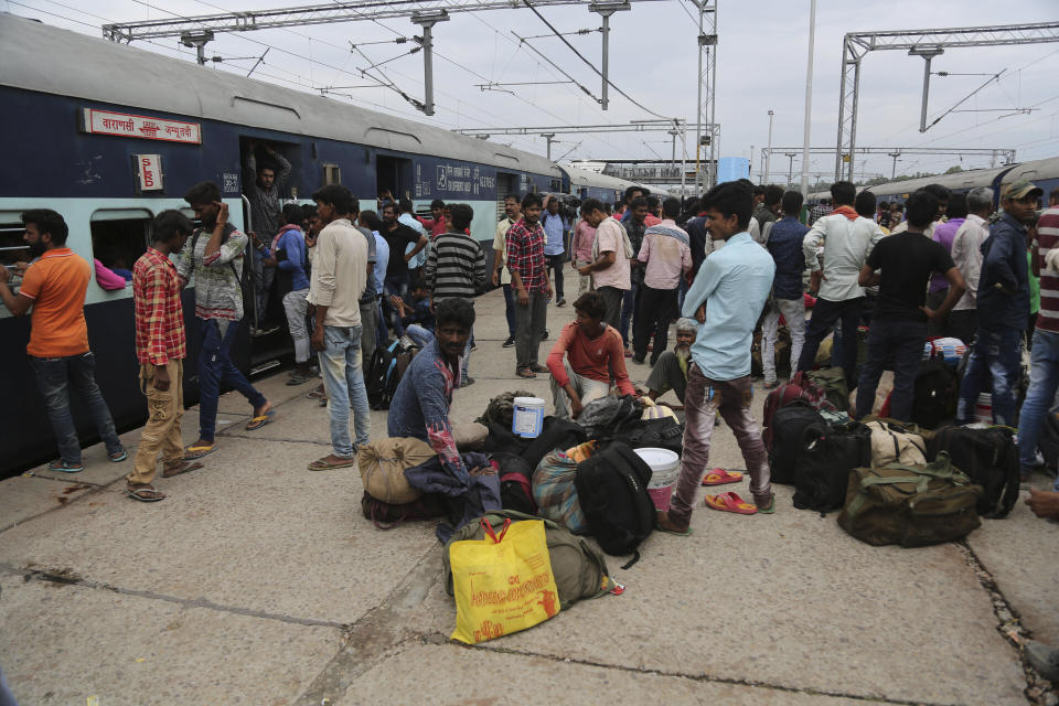 Indian migrant laborers wait at a railway station to leave the region in Jammu, India, Wednesday, Aug. 7, 2019. Indian lawmakers passed a bill Tuesday that strips statehood from the Indian-administered portion of Muslim-majority Kashmir, which remains under an indefinite security lockdown, actions that archrival Pakistan warned could lead to war. (AP Photo/Channi Anand)