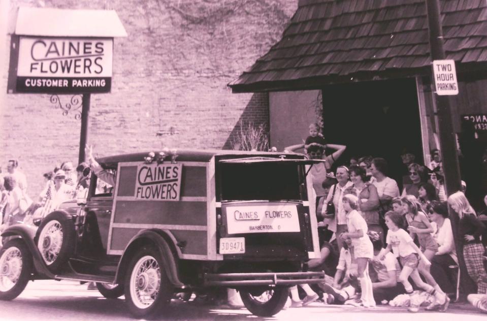 A photo from the 1970s shows the Caine's Flowers 1931 Chevy Woody at the shop in downtown Barberton. A young Bunde Roebuck is watching at far right, near the two-hour parking pole.