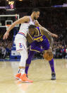 Philadelphia 76ers' Ben Simmons, left, of Australia, tries to reach around Los Angeles Lakers' LeBron James, right, for the ball during the first half of an NBA basketball game, Sunday, Feb. 10, 2019, in Philadelphia. (AP Photo/Chris Szagola)