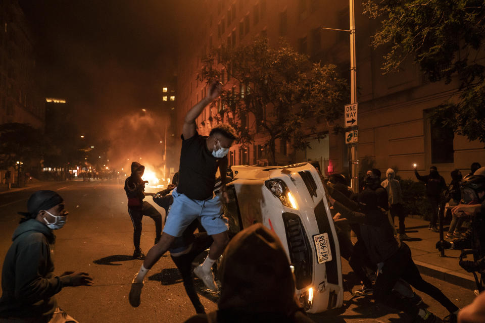 Demonstrators vandalize a car as they protest the death of George Floyd, May 31, 2020, near the White House in Washington, D.C. Floyd died after being restrained by Minneapolis police officers. The image was part of a series of photographs by The Associated Press that won the 2021 Pulitzer Prize for breaking news photography. (AP Photo/Evan Vucci)