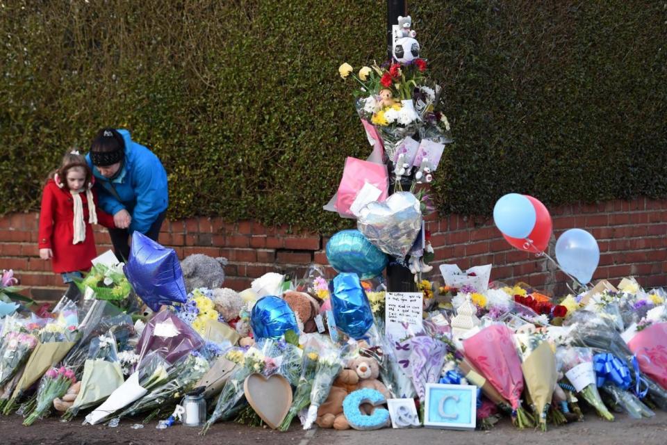 People leave floral tributes close to the scene in Coventry (PA)