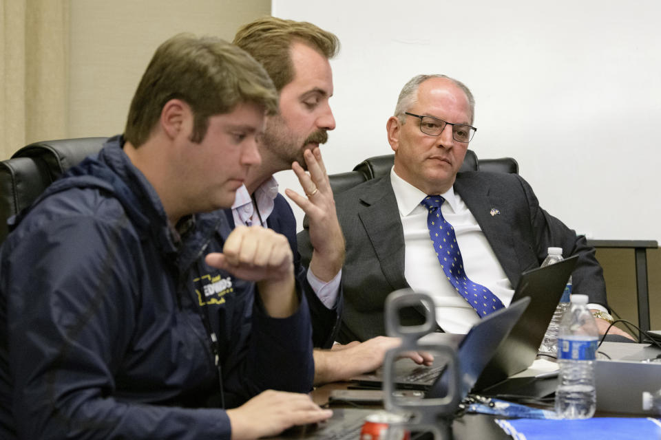 Louisiana Gov. John Bel Edwards listens to pollster Zac McCrary, left, and David Turner, Communications Director of the Democratic Governor's Association, as results arrive at his election night watch party in Baton Rouge, La., Saturday, Nov. 16, 2019. (AP Photo/Matthew Hinton)