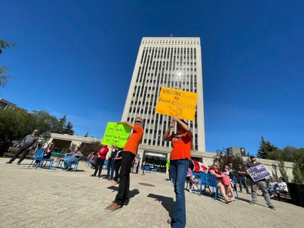 Approximately 100 anti-vaccine passport protesters gathered in front of city hall Wednesday afternoon to voice their opposition with signs and speeches.  (Richard Agecoutay/CBC - image credit)