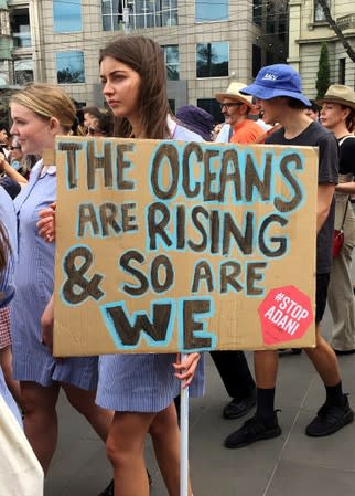 A protester displays a sign as she takes part in a protest to call for action on climate change in Melbourne