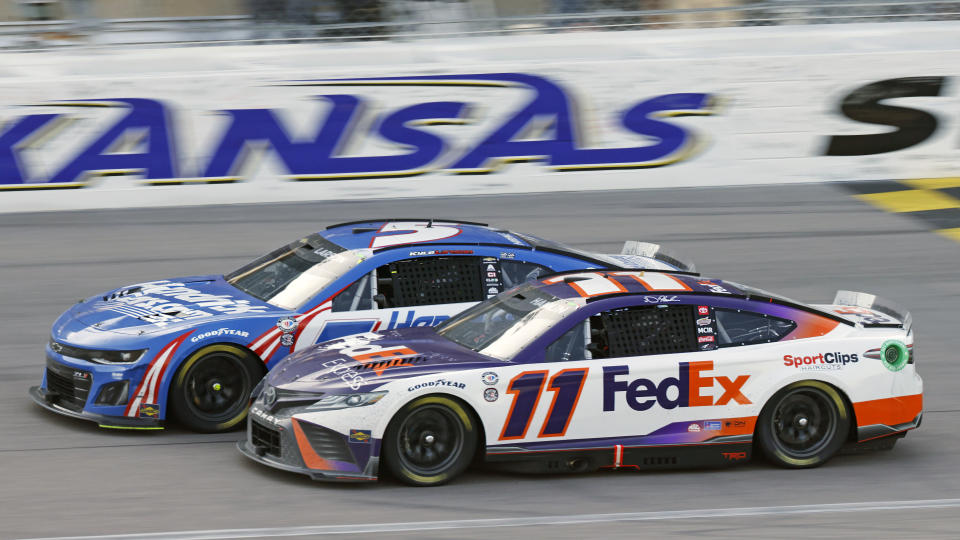 Kyle Larson (5) and Denny Hamlin (11) head down the front staightaway as they battle for the lead during a NASCAR Cup Series auto race at Kansas Speedway in Kansas City, Kan., Sunday, May 7, 2023. (AP Photo/Colin E. Braley)