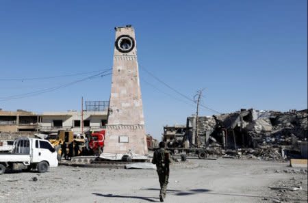 A fighter of Syrian Democratic Forces walks towards a clock tower in Raqqa, Syria October 18, 2017. Picture taken October 18, 2017. REUTERS/Erik De Castro