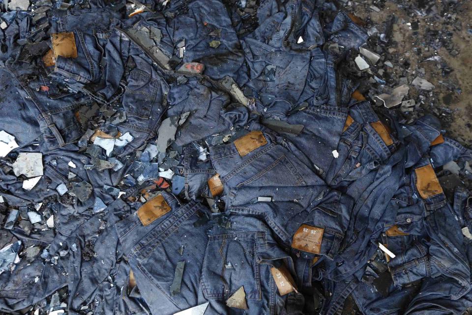 Burnt clothes are seen in front of a Standard Group garment factory which was on fire in Gazipur