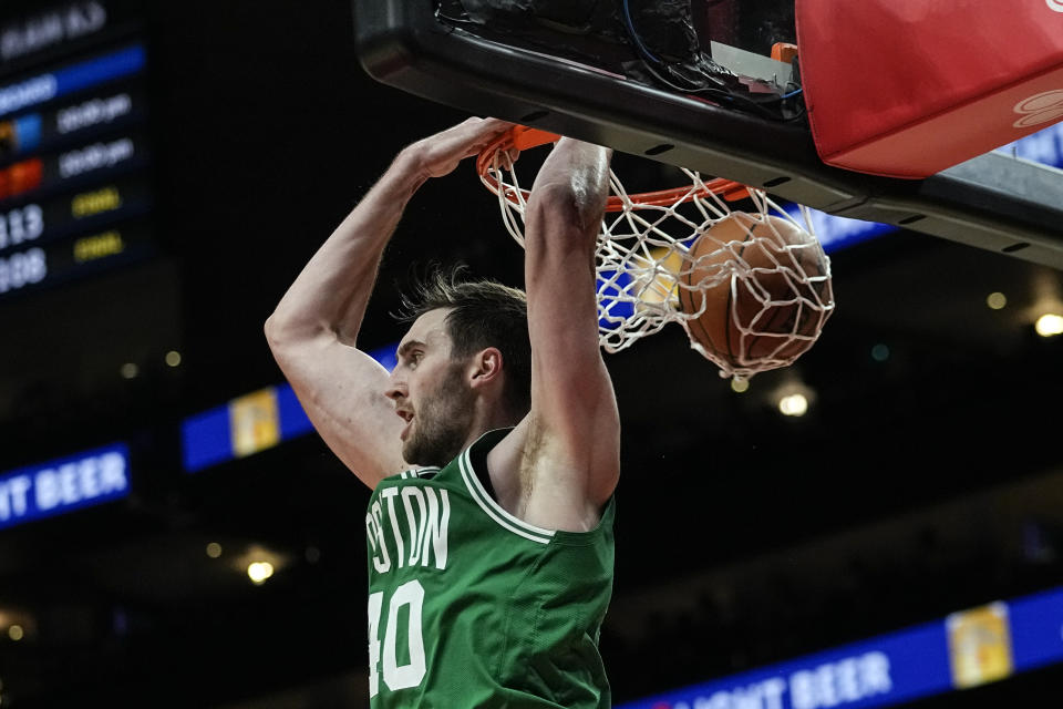 Boston Celtics center Luke Kornet (40) scores with a behind-the-head dunk during the second half of an NBA basketball game against the Atlanta Hawks Wednesday, Nov. 16, 2022 in Atlanta. (AP Photo/John Bazemore)