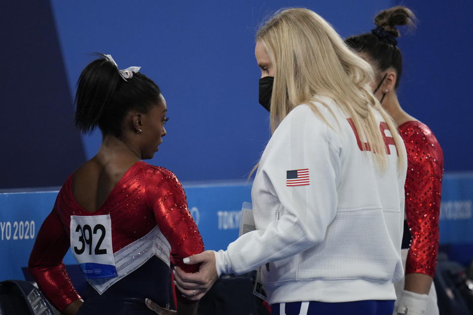 FILE - In this July 27, 2021 file photo, Simone Biles, of the United States, talks with her coach after performing on the vault during the artistic gymnastics women's final at the 2020 Summer Olympics, in Tokyo. Biles and Naomi Osaka are prominent young Black women under the pressure of a global Olympic spotlight that few human beings ever face. But being a young Black woman -- which, in American life, comes with its own built-in pressure to perform -- entails much more than meets the eye.(AP Photo/Gregory Bull, File)