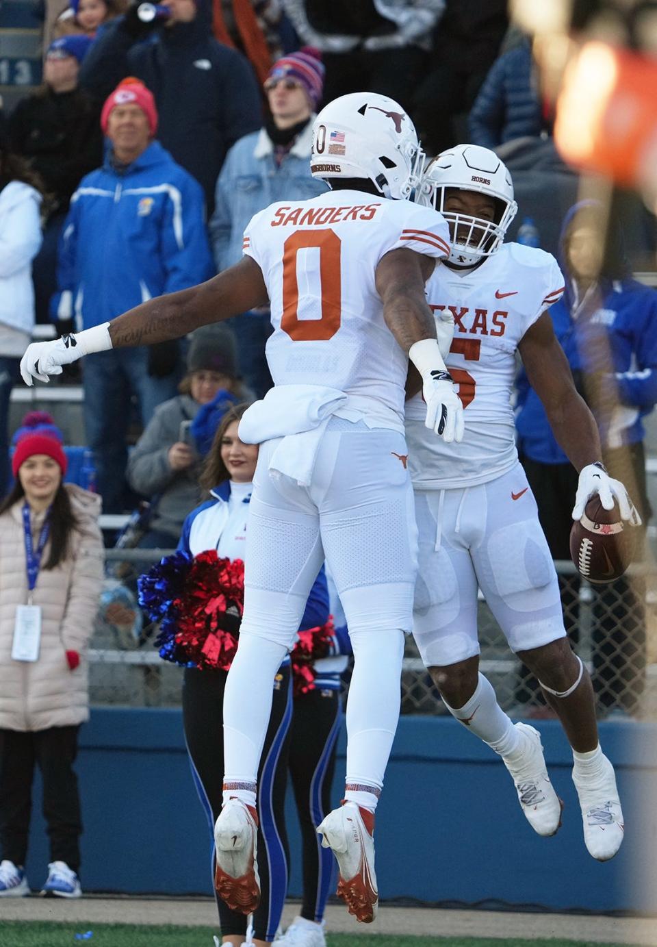 Texas running back Bijan Robinson, right, and tight end Ja'Tavion Sanders celebrate one of Robinson's three first-half touchdowns in Saturday's game at Kansas.