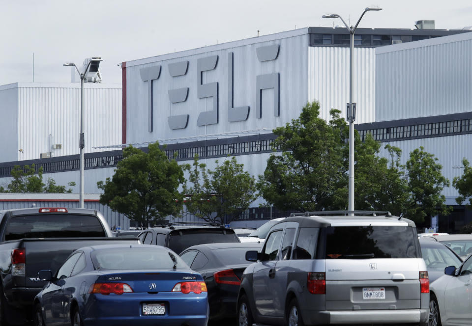 This photo shows vehicles in the parking lot of the Tesla electric car plant Wednesday, May 13, 2020, in Fremont, Calif. The Alameda County Public Health Department announced on Twitter late Tuesday that the Fremont, California, plant will be able to go beyond basic operations this week and start making vehicles Monday, as long as it delivers on worker safety precautions that it agreed to. (AP Photo/Ben Margot)