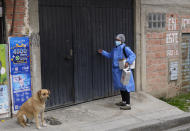 A healthcare worker knocks on the door of a house during a door-to-door COVID-19 vaccination campaign, in La Paz, Bolivia, Sunday, Jan. 16, 2022. (AP Photo/Juan Karita)