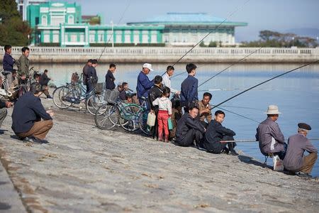 People fish in the Bay of Wonsan, North Korea October 2016. The hotel in the background is scheduled for refurbishment as part of a massive project to redesign the entire city centre. Christian Peterson-Clausen/Handout via REUTERS