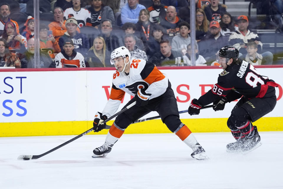 Philadelphia Flyers' Sean Walker, left, skates past Ottawa Senators' Jake Sanderson during the second period of an NHL hockey game, Saturday, March 2, 2024, in Philadelphia. (AP Photo/Matt Slocum)