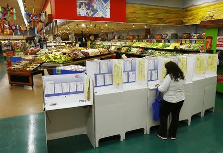 A woman votes from a polling station located inside a local grocery store during U.S. midterm elections in National City, California November 4, 2014.REUTERS/Mike Blake