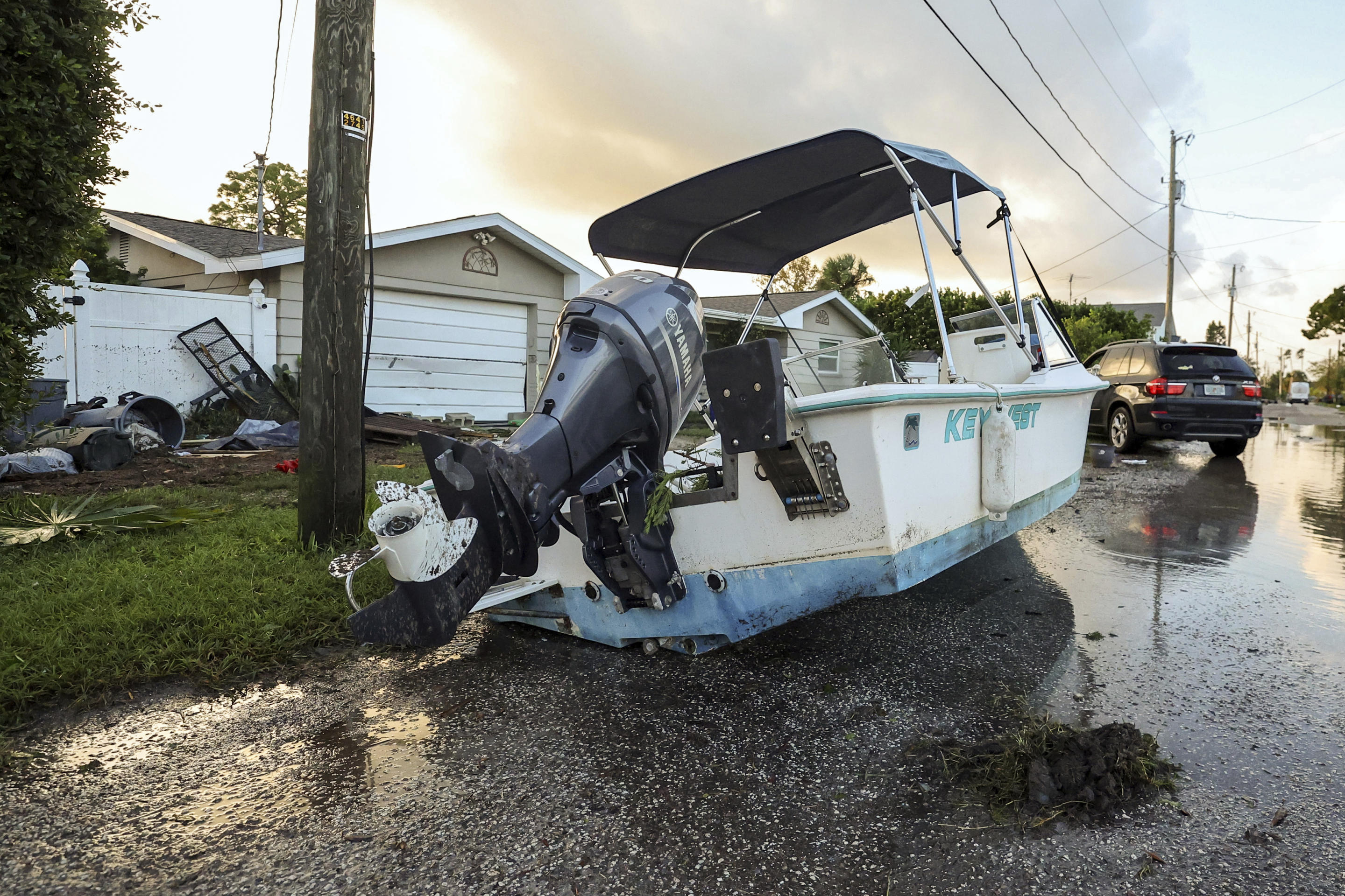 A boat lies on a road after being relocated during flooding from Hurricane Helene on Friday in Hudson, Florida. 