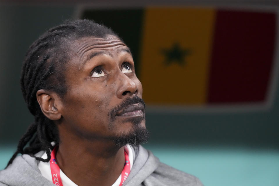 Senegal's head coach Aliou Cisse listens to the nationals anthems prior to the World Cup round of 16 soccer match between England and Senegal, at the Al Bayt Stadium in Al Khor, Qatar, Sunday, Dec. 4, 2022. (AP Photo/Frank Augstein)