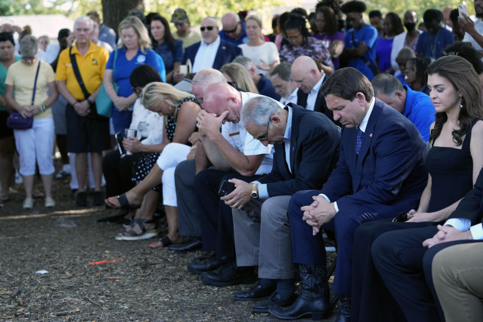 Florida Gov. Ron DeSantis, second from right, and his wife Casey, right, bow their heads during a prayer at a vigil for the victims of Saturday's mass shooting Sunday, Aug. 27, 2023, in Jacksonville, Fla. (AP Photo/John Raoux)