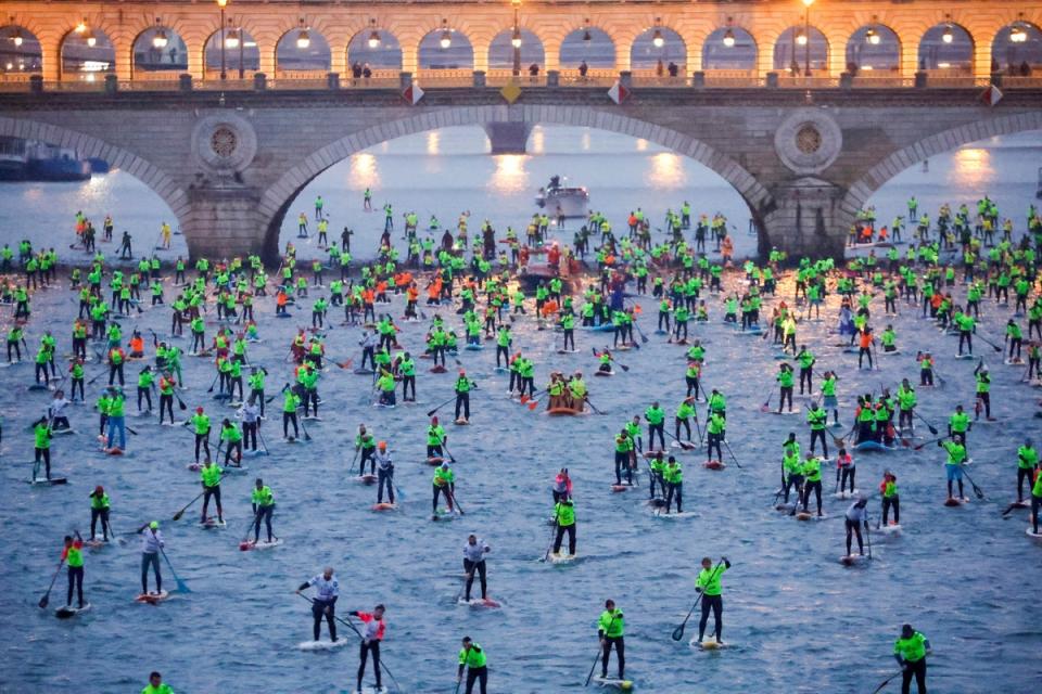 4 December 2022: Participants start in the 12th Edition of the Nautic SUP Paris Crossing stand up paddle competition on the river Seine in Paris (Reuters)