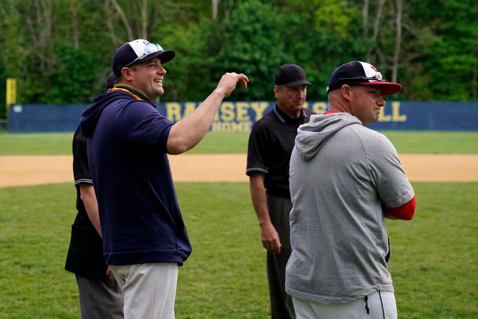 Ramsey head coach Paul Urbanovich, left, talks over the rules of the field with the umpires and his brother, Westwood head coach Nick Urbanovich, ahead of their game on Monday, May 17, 2021, in Ramsey.