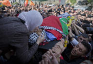 FILE - In this March 21, 2019 file photo, Wafa Manasra, mother of Palestinian Ahmad Manasra, kisses him goodbye during his funeral in the West Bank village of Wad Fokin, near Bethlehem. In August 2020, Israeli military prosecutors offered three months of community service to a soldier who shot and killed Manasra, an unarmed Palestinian man who exited his vehicle to assist a second motorist who had also been shot -- in a case that has drawn renewed attention to a justice system that Palestinians and human rights activists say has created an atmosphere of impunity. The deal is now being reviewed by the Israeli Supreme Court. (AP Photo/Nasser Nasser, File)