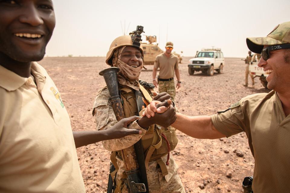 Drew, a Special Forces weapons sergeant, right, shakes hand and shares a laugh with a Nigerien EFoN soldier, March 8, 2022.