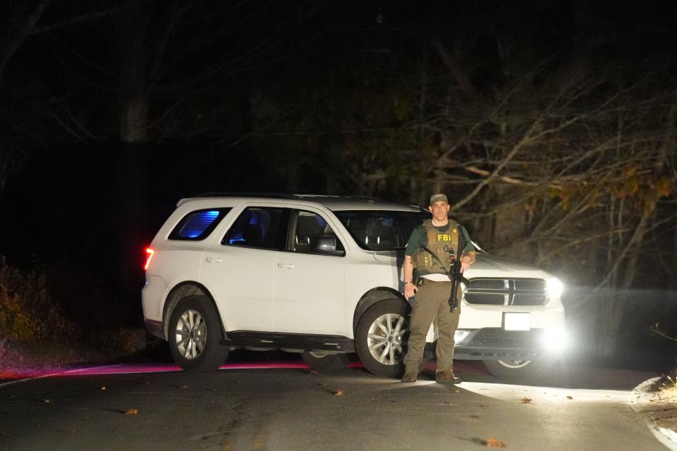 A law enforcement officer blocks a road in Bowdoin, Maine, Thursday, Oct. 26, 2023 during a manhunt for the suspect of Lewiston, Maine mass shootings. (AP Photo/Matt Rourke)