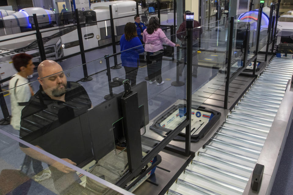 A TSA official demonstrates new screening equipment at Harry Reid International Airport, Wednesday, March 6, 2024, in Las Vegas. (AP Photo/Ty ONeil)