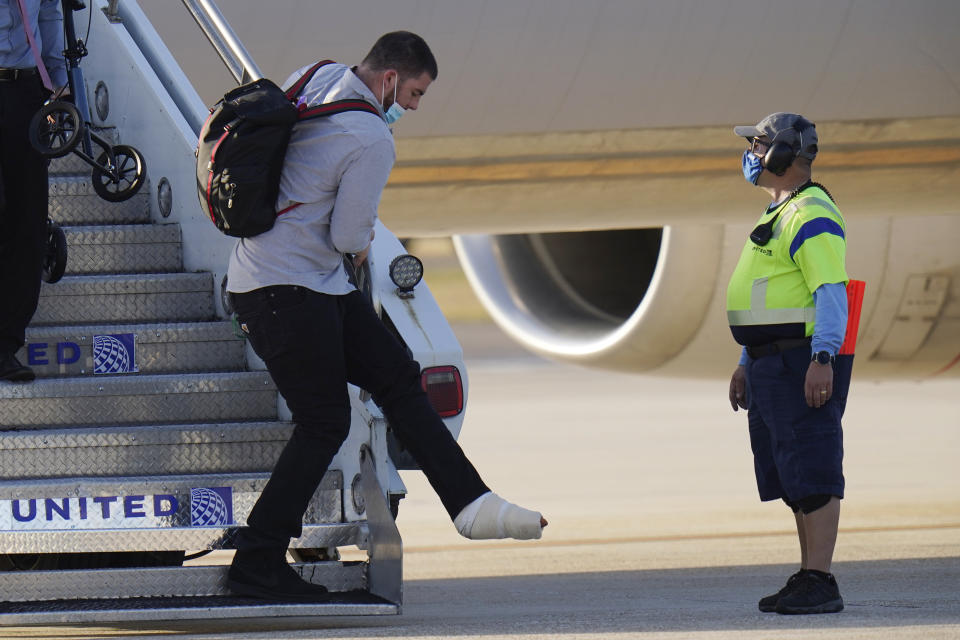 Kansas City Chiefs left tackle Eric Fisher gets off the plane with his teammates ahead of the NFL Super Bowl 55 football game against the Tampa Bay Buccaneers, Saturday, Feb. 6, 2021, in Tampa, Fla. Fisher tore his Achilles tendon during the AFC Championship against the Buffalo Bills. (AP Photo/Chris O'Meara)