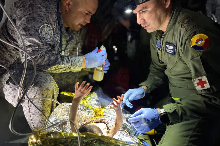 Esta foto difundida por la Presidencia de Colombia muestra a miembros del Ejército colombiano revisando a uno de los cuatro niños indígenas que fueron encontrados con vida después de estar perdidos durante 40 días en la selva amazónica colombiana tras un accidente aéreo en Bogotá, el 10 de junio de 2023. 