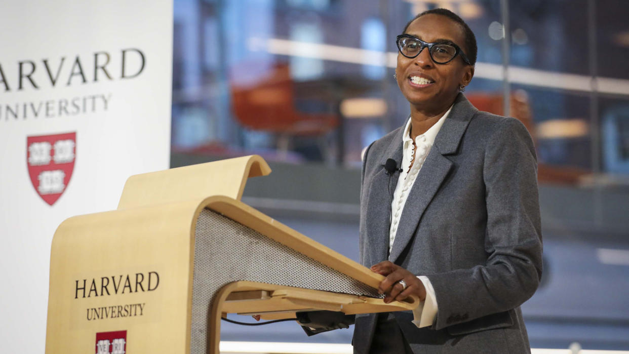 Claudine Gay in a gray jacket with white shirt at a bentwood podium saying Harvard University.