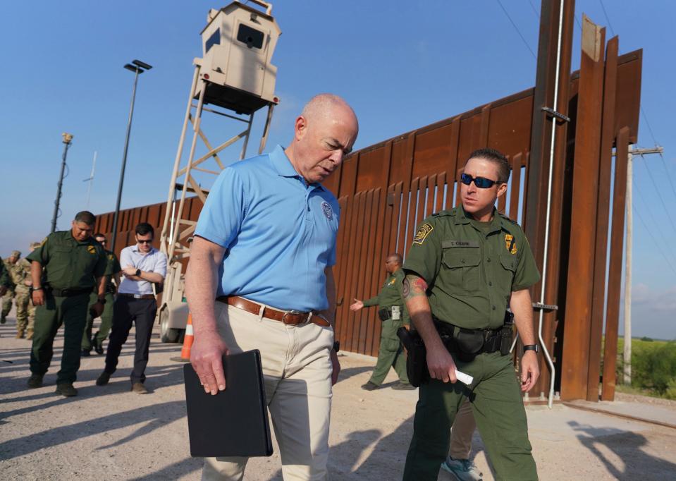 Homeland Security Secretary Alejandro Mayorkas, left, listens to Anthony Crane, deputy patrol agent in charge of the U.S. Border Patrol, as he tours the section of the border wall on May 17, 2022, in Hidalgo, Texas.