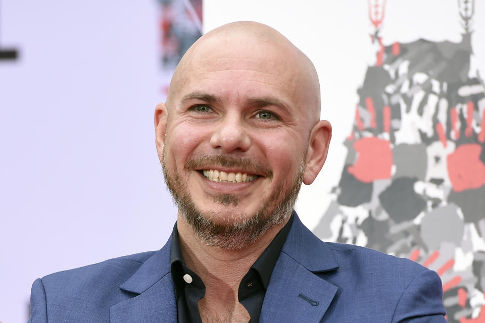 FILE - Pitbull smiles during a hand and footprint ceremony at the TCL Chinese Theatre in Los Angeles, in this Friday, Dec. 14, 2018, file photo. NASCAR is being heavily promoted by a broadcast partner as about to embark on “The Best Season Ever” and on paper that could be true. NASCAR this year will race on dirt for the first time since 1970, the schedule includes a whopping seven road courses and five venues new to the Cup Series. Michael Jordan and Pitbull are among new team owners entering the sport in 2021 and Chase Elliott, NASCAR’s most popular driver, is the reigning champion. (Photo by Chris Pizzello/Invision/AP, File)