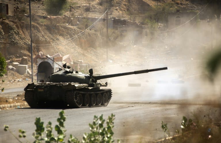 A fighter loyal to Yemen's exiled President Abedrabbo Mansour Hadi fires from a tank during clashes with Shiite Huthi rebels west of the city of Taez on March 21, 2016