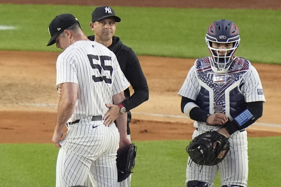 New York Yankees catcher Jose Trevino, right, watches as manager Aaron Boone takes pitcher Carlos Rodón, left, out of the game during the sixth inning of a baseball game against the Cincinnati Reds, Wednesday, July 3, 2024, in New York. (AP Photo/Frank Franklin II)