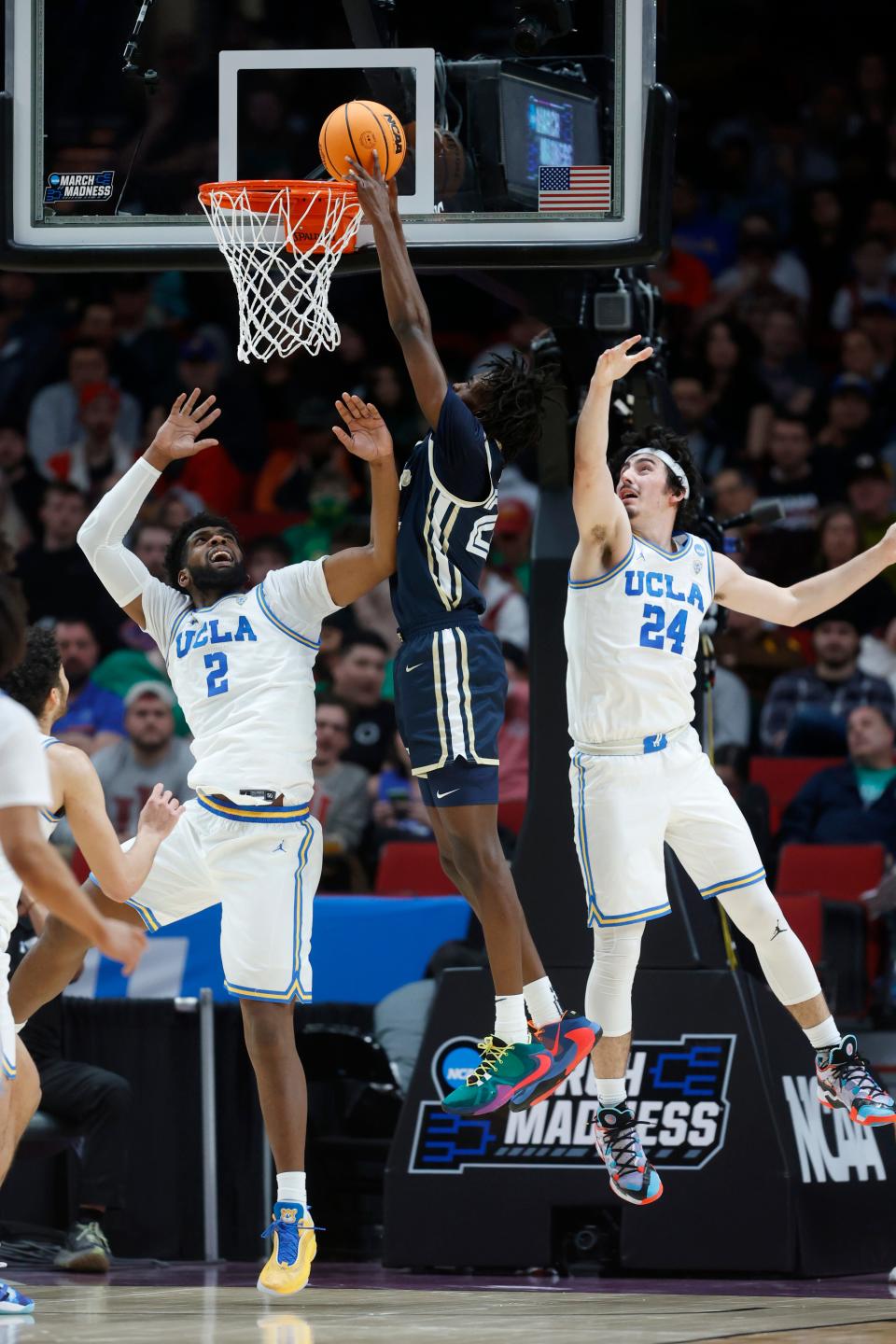 Akron forward Ali Ali, center, dunks as UCLA forward Cody Riley (2) and UCLA guard Jaime Jaquez Jr. (24) defend during a first-round NCAA college basketball tournament game March 17, 2022, in Portland, Ore.
