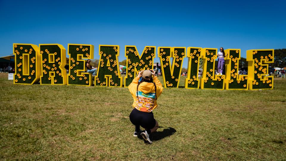 Another festival-goer takes a photo of her friends atop the Dreamville sign welcoming attendees to the event. - Credit: Greg Noire