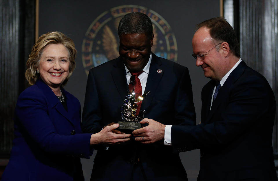 WASHINGTON, DC - FEBRUARY 25:  Former U.S. Secretary of State Hillary Clinton (L) presents the Hillary Rodham Clinton Awards for Advancing Women in Peace and Security to Dr. Denis Mukwege (C), founder of Panzi Hospital in the Democratic Republic of the Congo, with Georgetown University President John DeGioia (R) at Georgetown University February 25, 2014 in Washington, DC. (Photo by Win McNamee/Getty Images)