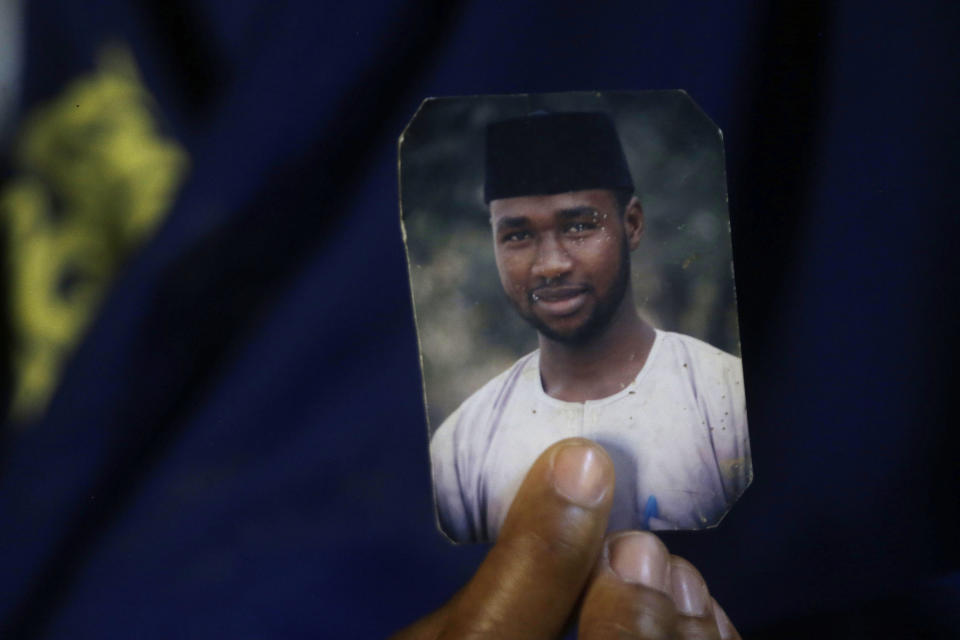 FILE - Amina Ahmed, the wife of Muhammad Mubarak Bala, an atheist who has been detained since April 2020, holds his picture in her home in Abuja, Nigeria, Sunday, Nov. 21, 2021. Bala is an outspoken atheist in a deeply religious country; his alleged crime: Posting blasphemous statements online. (AP Photo/Sunday Alamba, File)