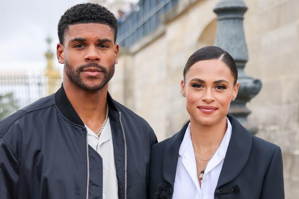 <p>Arnold Jerocki/GC Images</p> Andre Levrone and Sydney McLaughlin attends the Christian Dior Womenswear Spring/Summer 2023