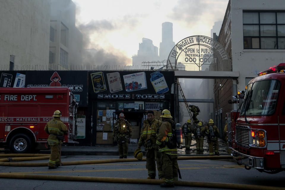 Los Angeles Fire Department firefighters work the scene of a structure fire that injured multiple firefighters, according to a fire department spokesman, Saturday, May 16, 2020, in Los Angeles. (AP Photo/Ringo H.W. Chiu)