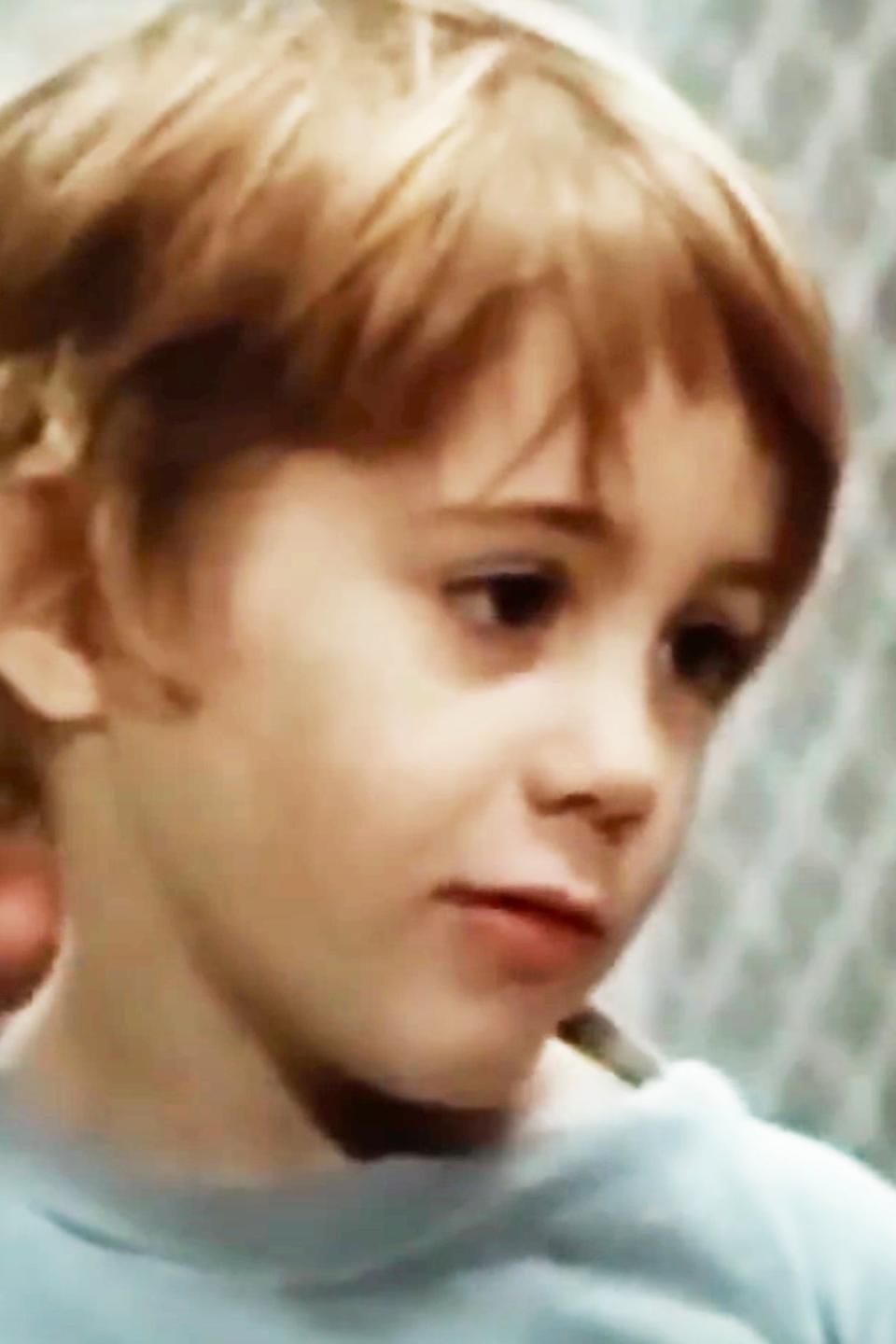 A young Robert Downey Jr. with short hair gazes off-camera, wearing a casual top. The background appears to be nondescript