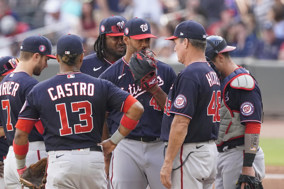 Washington Nationals pitching coach Jim Hickey (48) talks to starting pitcher Joe Ross (41) during a baseball game against the Atlanta Braves, Monday, May 31, 2021, in Atlanta. (AP Photo/John Bazemore)