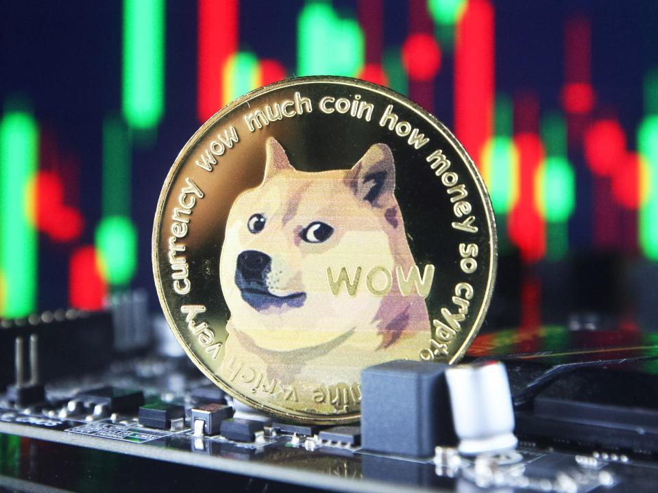 Dogecoin cryptocurrency coin and a graph are pictured in Kyiv on 08 July, 2021.