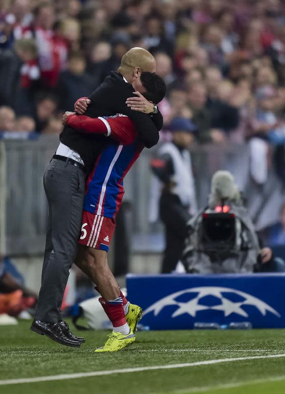 Bayern Munich's head coach Pep Guardiola (L) congratulates midfielder Thiago Alcantara during the UEFA Champions League second-leg quarter-final football match against Porto in Munich on April 21, 2015