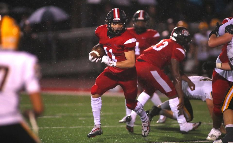 Aliquippa's Cameron Lindsey (11) sprints around Montour's defensive line during the first half of the WPIAL 4A playoff game Friday night at Jimbo Covert Field in Freedom, PA.