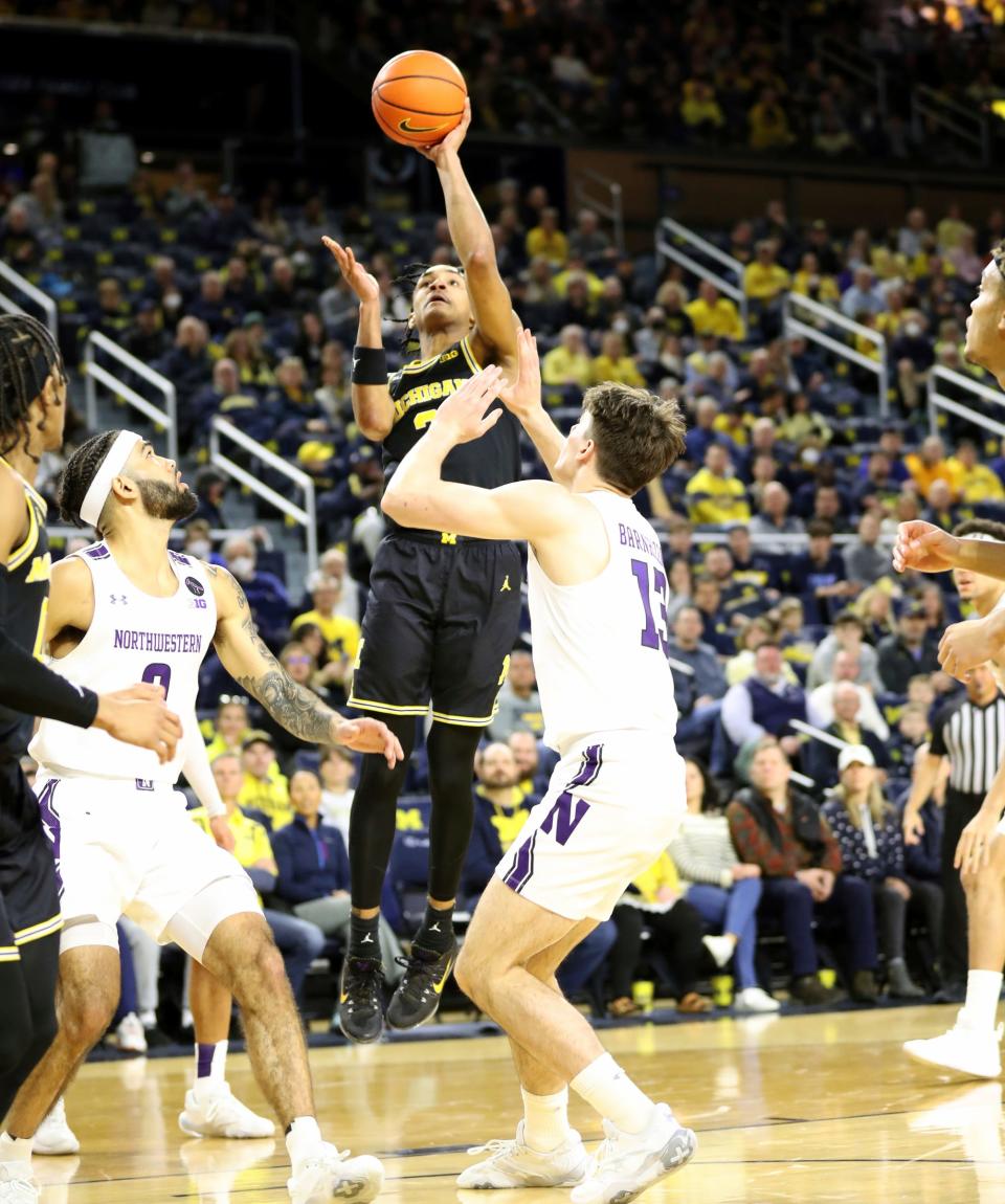 Michigan guard Kobe Bufkin (center) scores against Northwestern guard Brooks Barnhizer (right) during the first half Jan. 15, 2023 at Crisler Center in Ann Arbor.